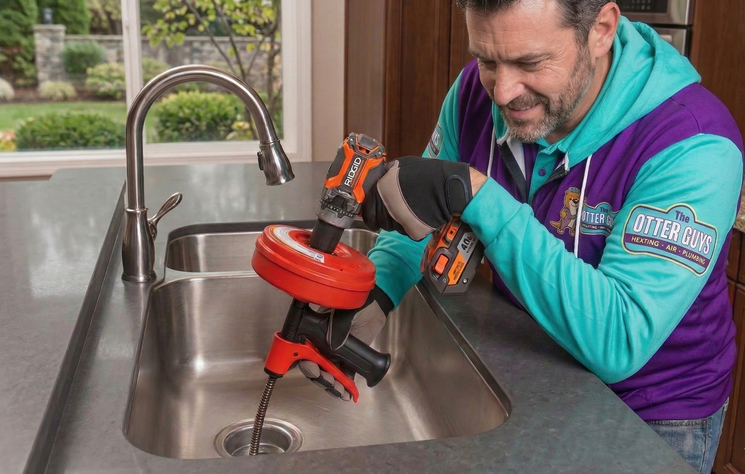 Otter Guys technician unclogging a kitchen sink with professional drain cleaning equipment